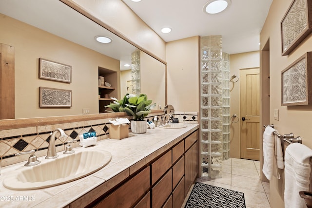 bathroom with tile patterned flooring, walk in shower, a sink, and double vanity