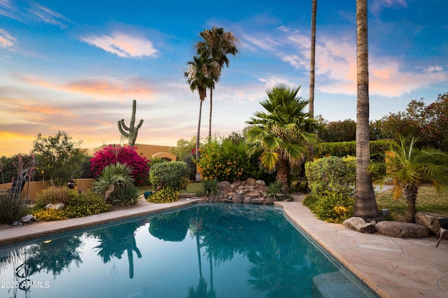 pool at dusk featuring an outdoor pool