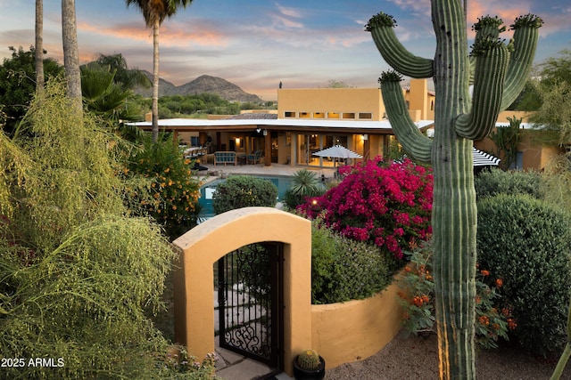 exterior space featuring a pool, fence private yard, a gate, and a mountain view