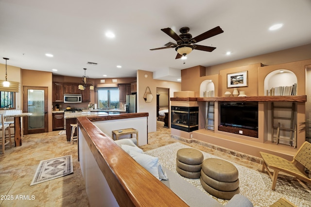 living room with recessed lighting, visible vents, a fireplace, and ceiling fan