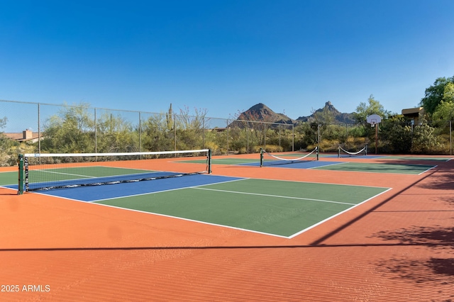 view of sport court featuring community basketball court, fence, and a mountain view