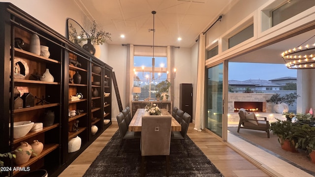 wine area with a wall of windows, hardwood / wood-style floors, a healthy amount of sunlight, and a notable chandelier