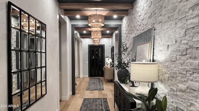 corridor with beamed ceiling and light hardwood / wood-style flooring