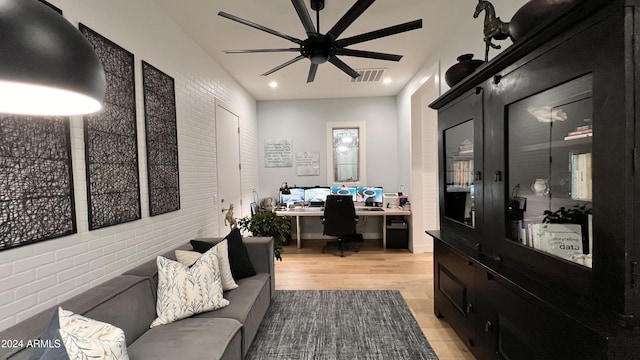 office featuring ceiling fan, built in desk, and light hardwood / wood-style flooring