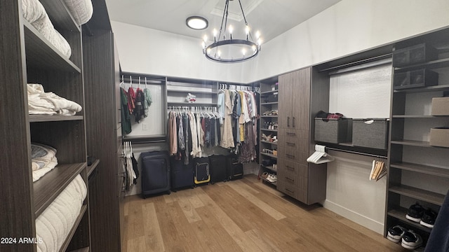 walk in closet featuring hardwood / wood-style floors and an inviting chandelier