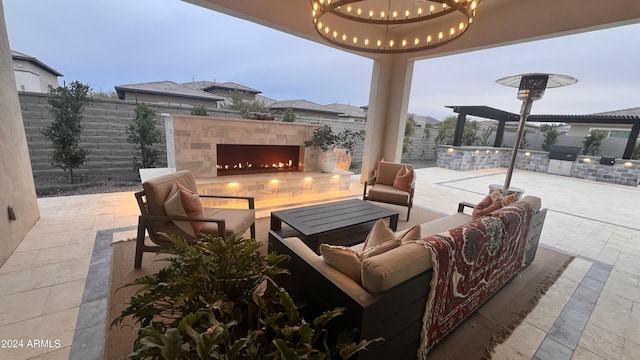 view of patio featuring an outdoor living space with a fireplace and an outdoor kitchen