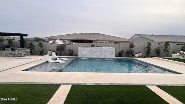 view of swimming pool featuring pool water feature and a patio