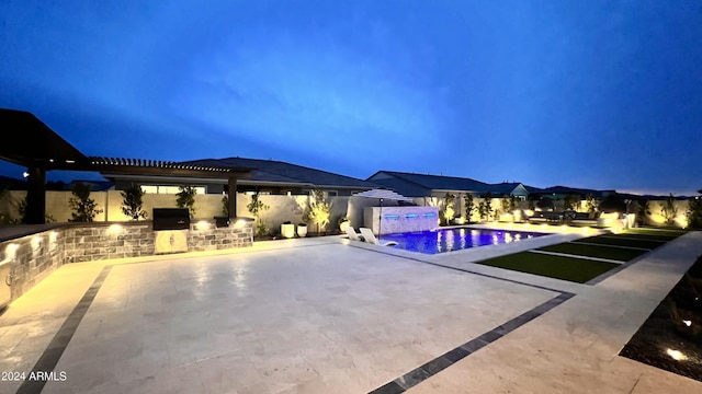 view of swimming pool featuring a patio area, pool water feature, and an outdoor kitchen