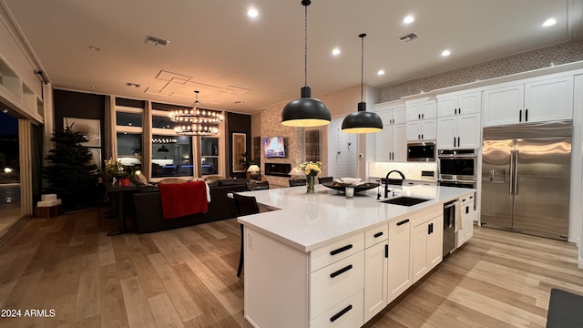 kitchen with white cabinetry, sink, an island with sink, and stainless steel appliances