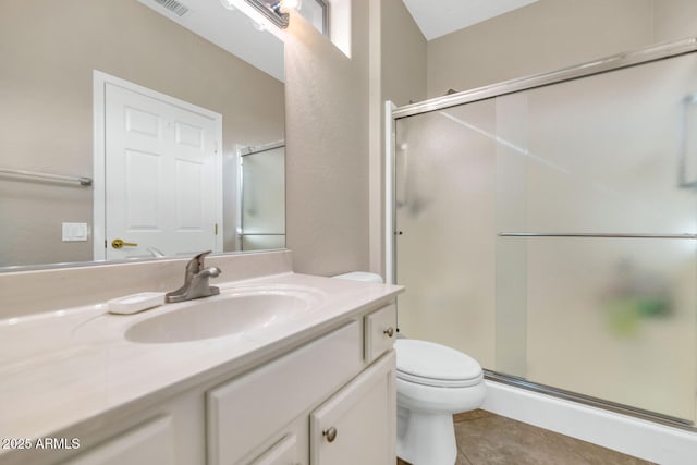 bathroom with toilet, tile patterned flooring, vanity, and walk in shower