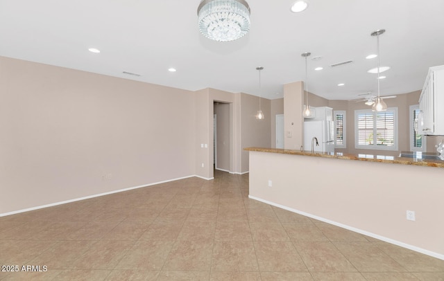 kitchen with white cabinets, decorative light fixtures, white refrigerator, and light tile patterned floors