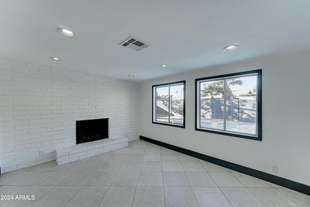 unfurnished living room with a fireplace and light tile patterned floors