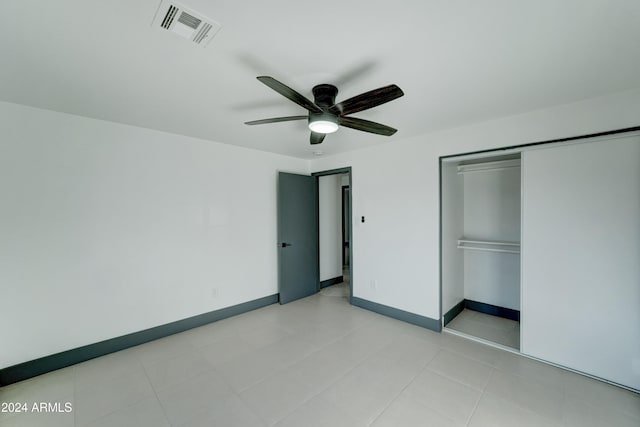 unfurnished bedroom with ceiling fan and a closet