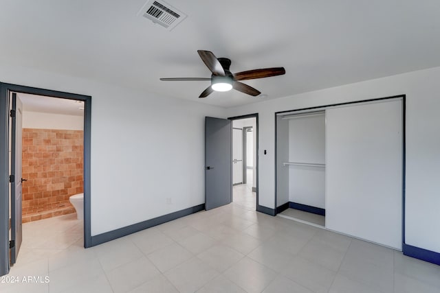 unfurnished bedroom featuring ceiling fan, a closet, and ensuite bath