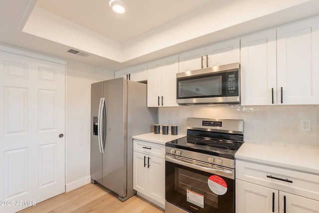 1301 N 44th St, Phoenix, AZ 85008 - kitchen with stainless steel appliances, light countertops, light wood-type flooring, and white cabinetry