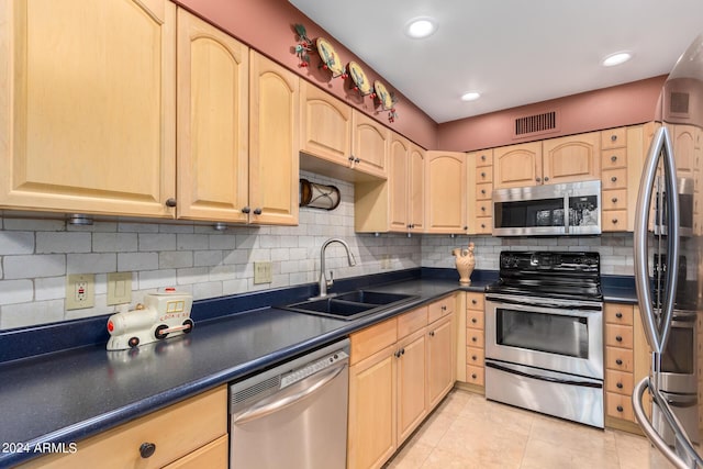 kitchen featuring sink, light tile patterned floors, appliances with stainless steel finishes, backsplash, and light brown cabinets