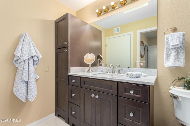 bathroom with vanity, toilet, and tile patterned flooring