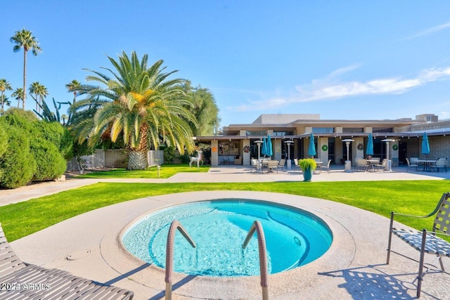 view of pool with a patio and a lawn