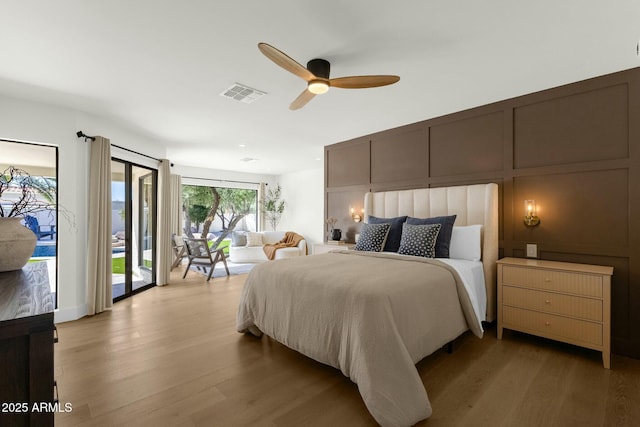 10013 N 106th Pl, Scottsdale, AZ 85258 - bedroom featuring visible vents, light wood finished floors, a ceiling fan, a decorative wall, and access to exterior