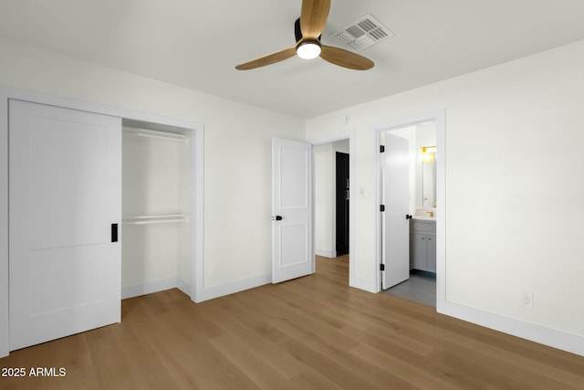 10013 N 106th Pl, Scottsdale, AZ 85258 - unfurnished bedroom featuring a closet, visible vents, baseboards, and wood finished floors