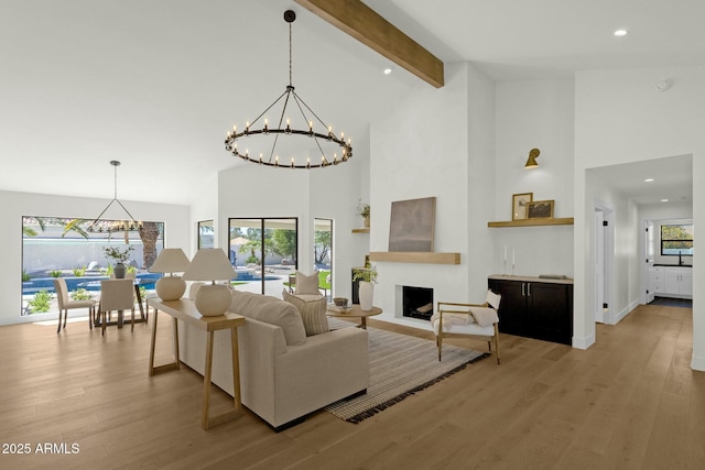 10013 N 106th Pl, Scottsdale, AZ 85258 - living room featuring a chandelier, beamed ceiling, light wood-style flooring, and plenty of natural light