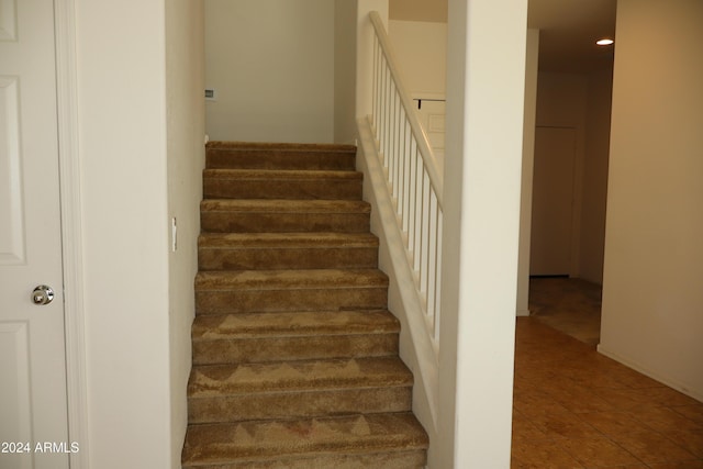 staircase featuring tile patterned flooring