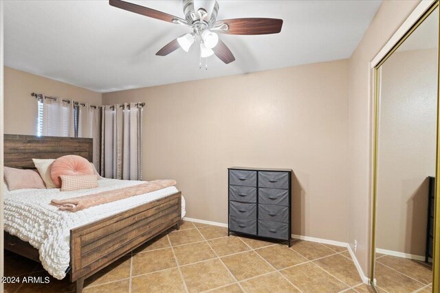 bedroom with a closet, tile patterned floors, and ceiling fan