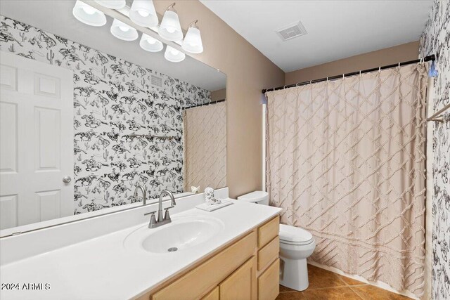 bathroom featuring toilet, walk in shower, vanity, and tile patterned floors