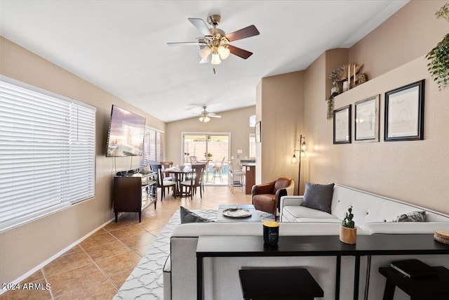 tiled living room with ceiling fan and vaulted ceiling