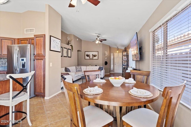 dining area featuring ceiling fan, vaulted ceiling, and light tile patterned floors