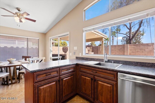 kitchen featuring lofted ceiling, kitchen peninsula, ceiling fan, light tile patterned floors, and dishwasher