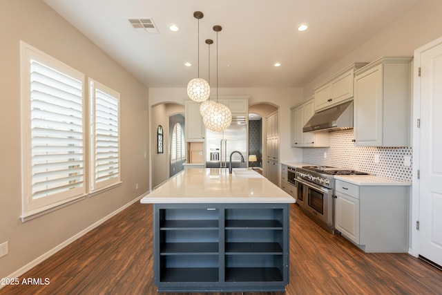 18283 N 93rd St, Scottsdale, AZ 85255 - kitchen featuring open shelves, under cabinet range hood, high quality appliances, arched walkways, and recessed lighting
