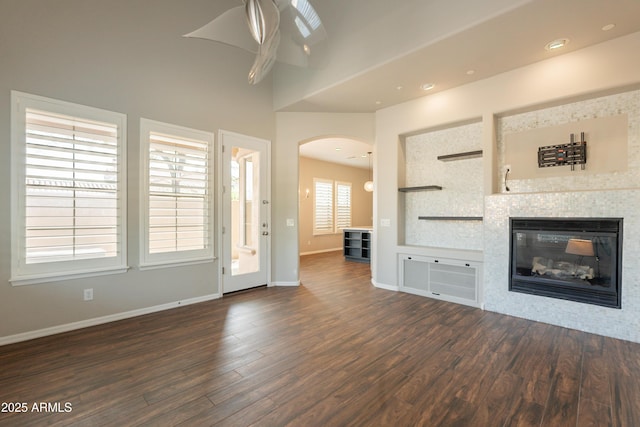 18283 N 93rd St, Scottsdale, AZ 85255 - unfurnished living room with dark wood finished floors, arched walkways, baseboards, ceiling fan, and recessed lighting