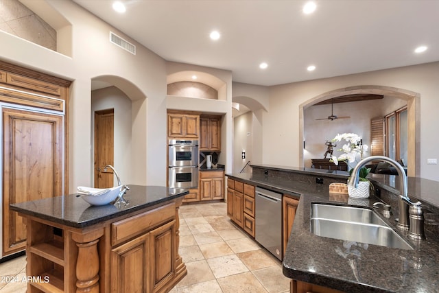 kitchen featuring ceiling fan, sink, appliances with stainless steel finishes, and an island with sink