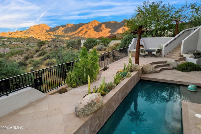 view of swimming pool featuring a mountain view and a patio