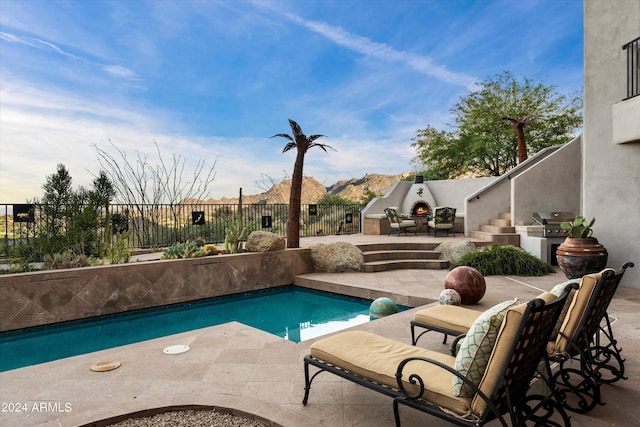 view of pool with an outdoor kitchen, grilling area, and a patio