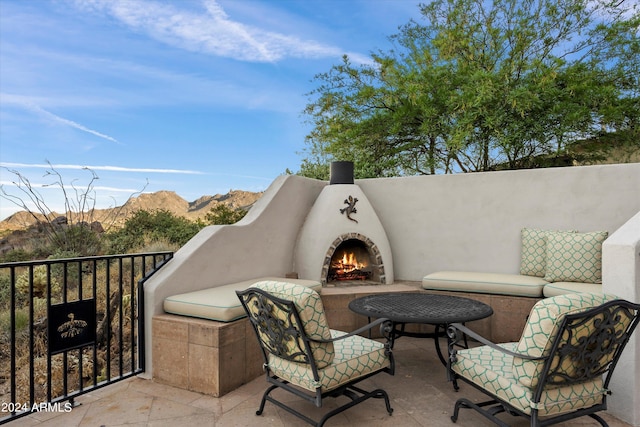 view of patio with a mountain view and exterior fireplace