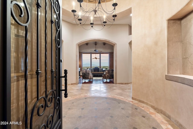 foyer entrance with ceiling fan with notable chandelier