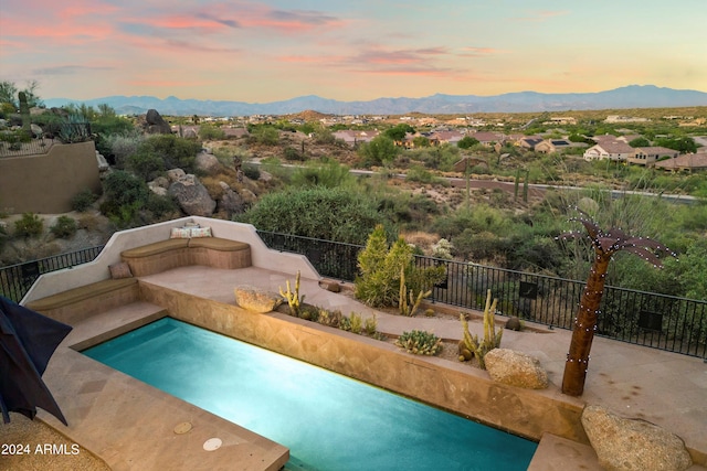 pool at dusk with a mountain view and a patio