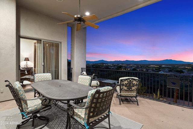 patio terrace at dusk with a mountain view and ceiling fan