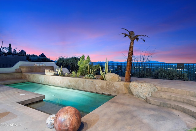 pool at dusk with a patio