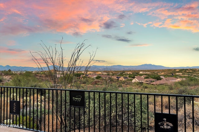 balcony at dusk featuring a mountain view