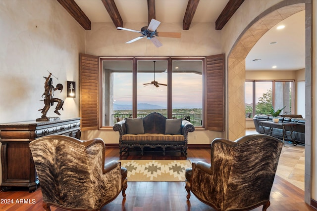 living room with hardwood / wood-style floors, beam ceiling, and plenty of natural light