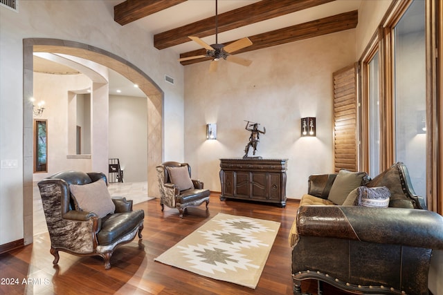 sitting room featuring ceiling fan, beam ceiling, and dark hardwood / wood-style flooring