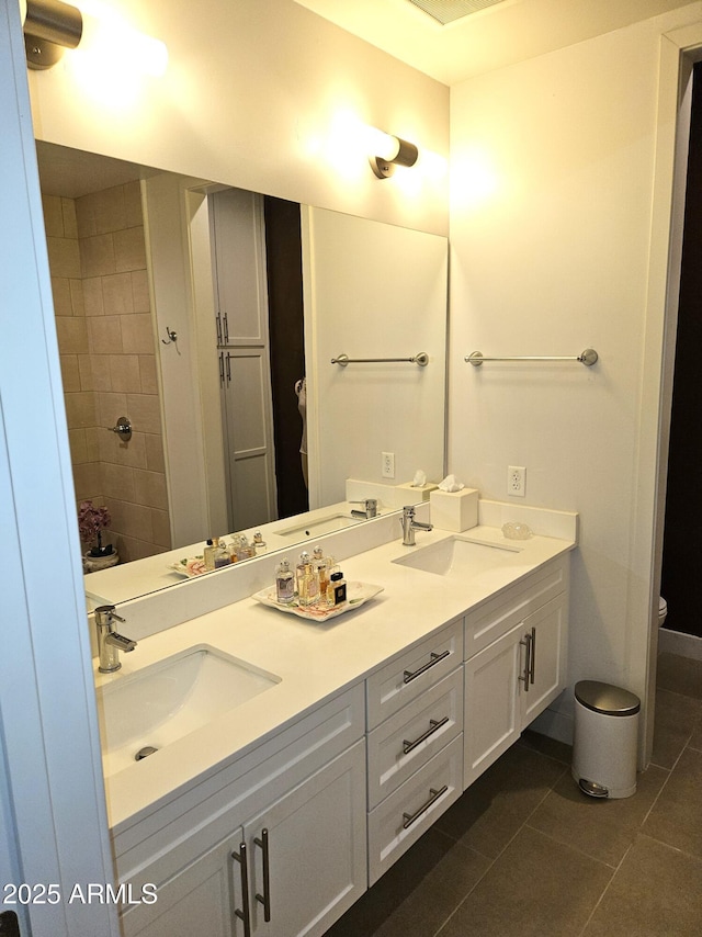 full bathroom with tile patterned flooring, double vanity, toilet, and a sink