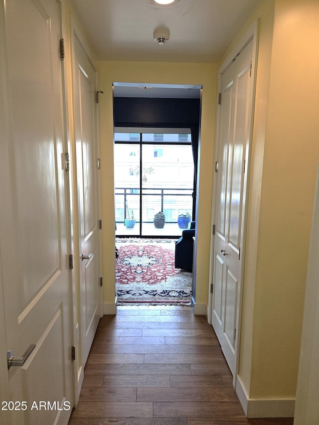 corridor with wood finished floors and baseboards