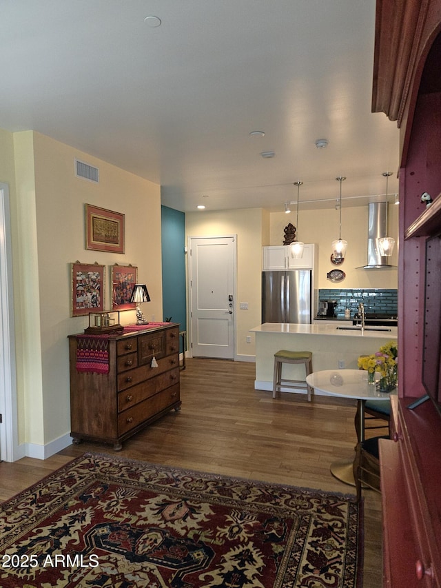interior space featuring visible vents, dark wood-style flooring, and baseboards