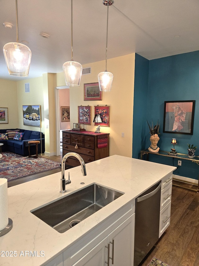 kitchen featuring a sink, light stone countertops, stainless steel dishwasher, and white cabinetry