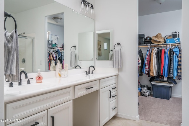 bathroom with tile patterned flooring, a shower with shower door, and vanity