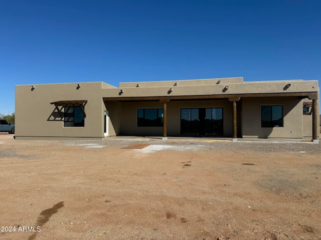 back of property featuring stucco siding